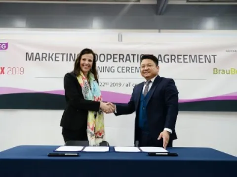 Andrea Kalrait (Nürnberg Messe Group) signing contract with Harper Lee (GMEG)